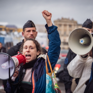 Action Greenpeace France, Les Amis de la Terre France et Alternatiba Paris dans le parc du Château de Versailles à l'occasion des 100 ans de Total le 26 mars 2024. Crédit : Mathilde Betis